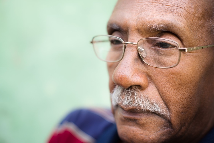 Senior man with glasses staring into the distance