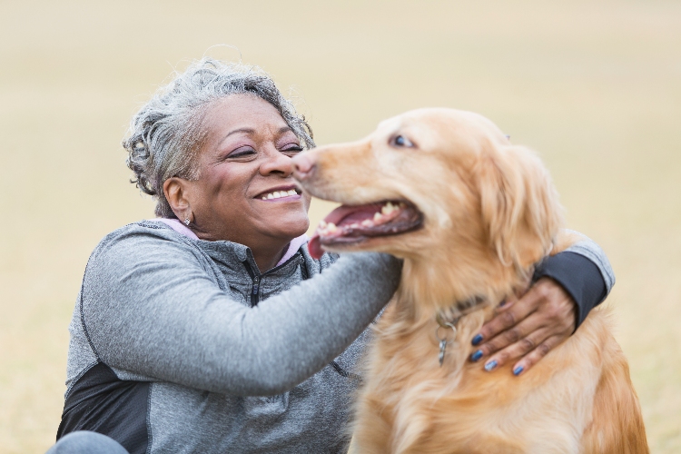 Senior women outside hugging her dog