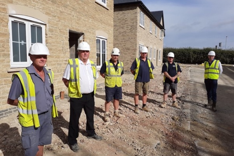 A group of men wearing safety vets and helmets
